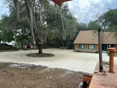 Graded drive curving past an office building with oak trees overhead