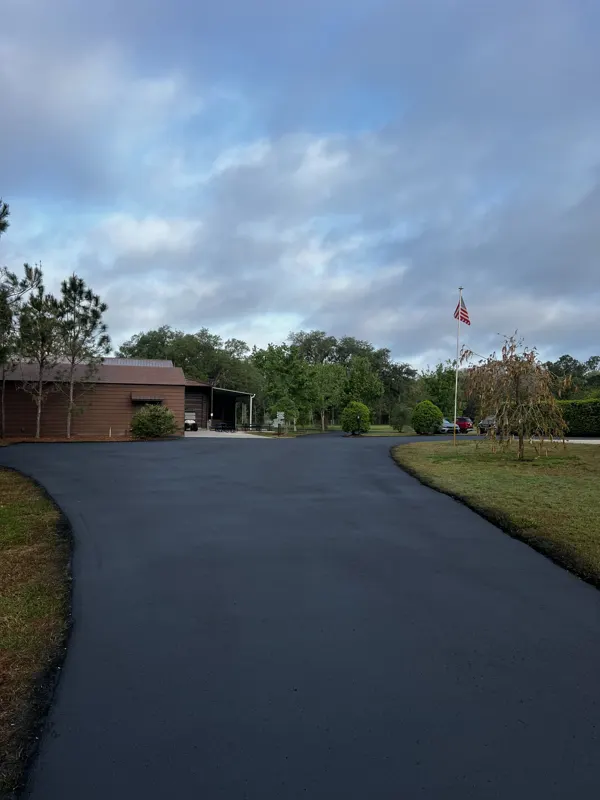 New asphalt drive curving toward a brick building