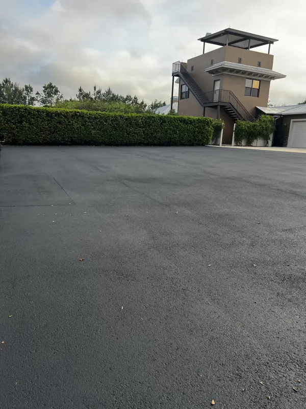 Large new asphalt surface in front of a house with an observation tower